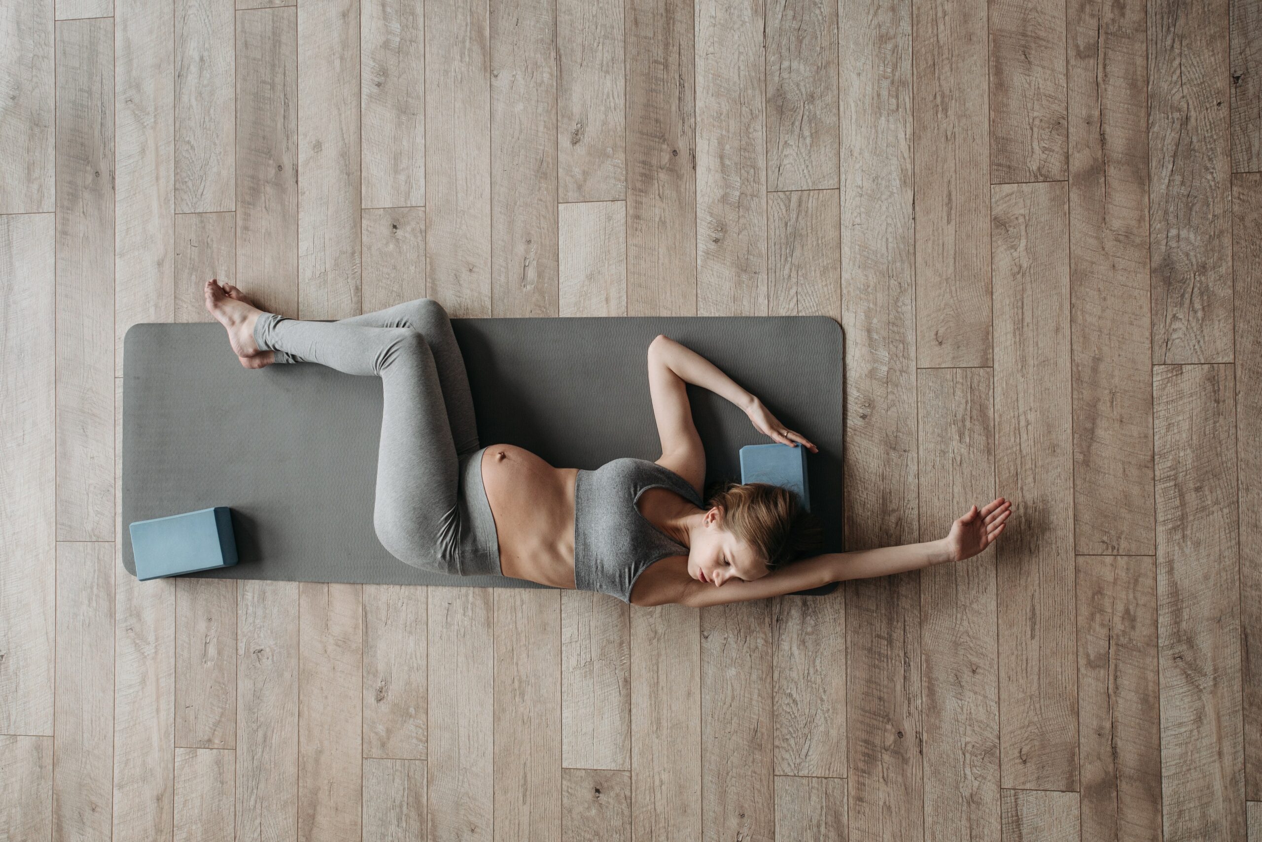 femme enceinte qui réalise un exercice de mobilité sur un tapis